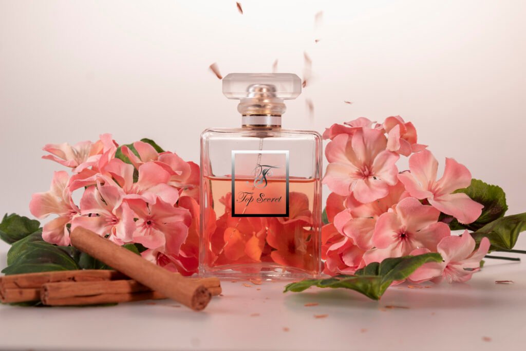 Top Secret: Serie de fotos tomadas para la marca de perfumes Top Secret, en la cual se muestra al bote de perfume rodeado de flores rosas en un fondo blanco, con trozos de canela siendo espolvoreados encima de esta.
