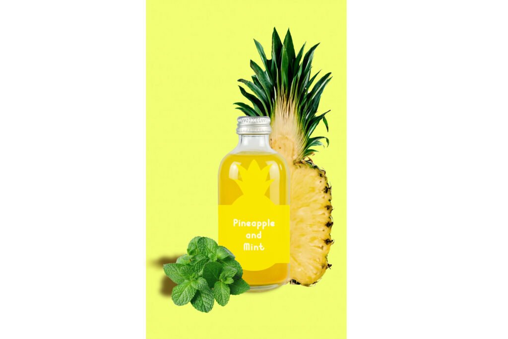 Foto compuesta de una botella de kombucha sabor piña y hierbabuena acompañado de media piña y hierbabuena